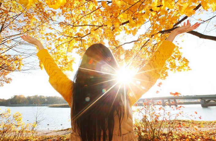 ©yellowj - stock.adobe.com Junge Frau nutzt die Herbst-Sonne.