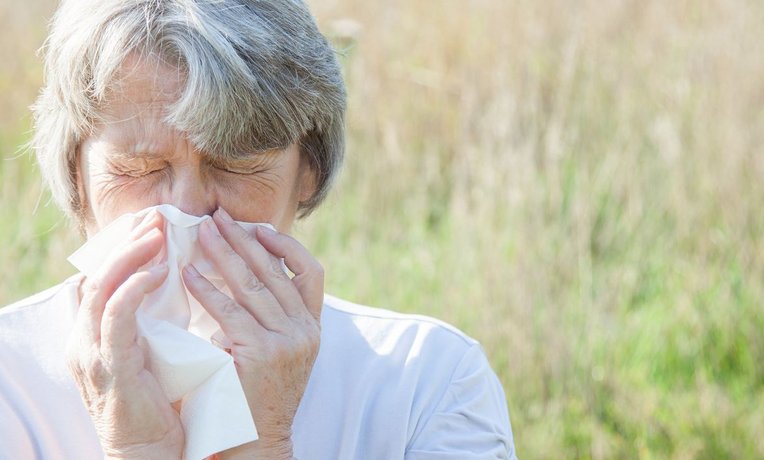 Ältere Frau mit Allergie-Symptomen.